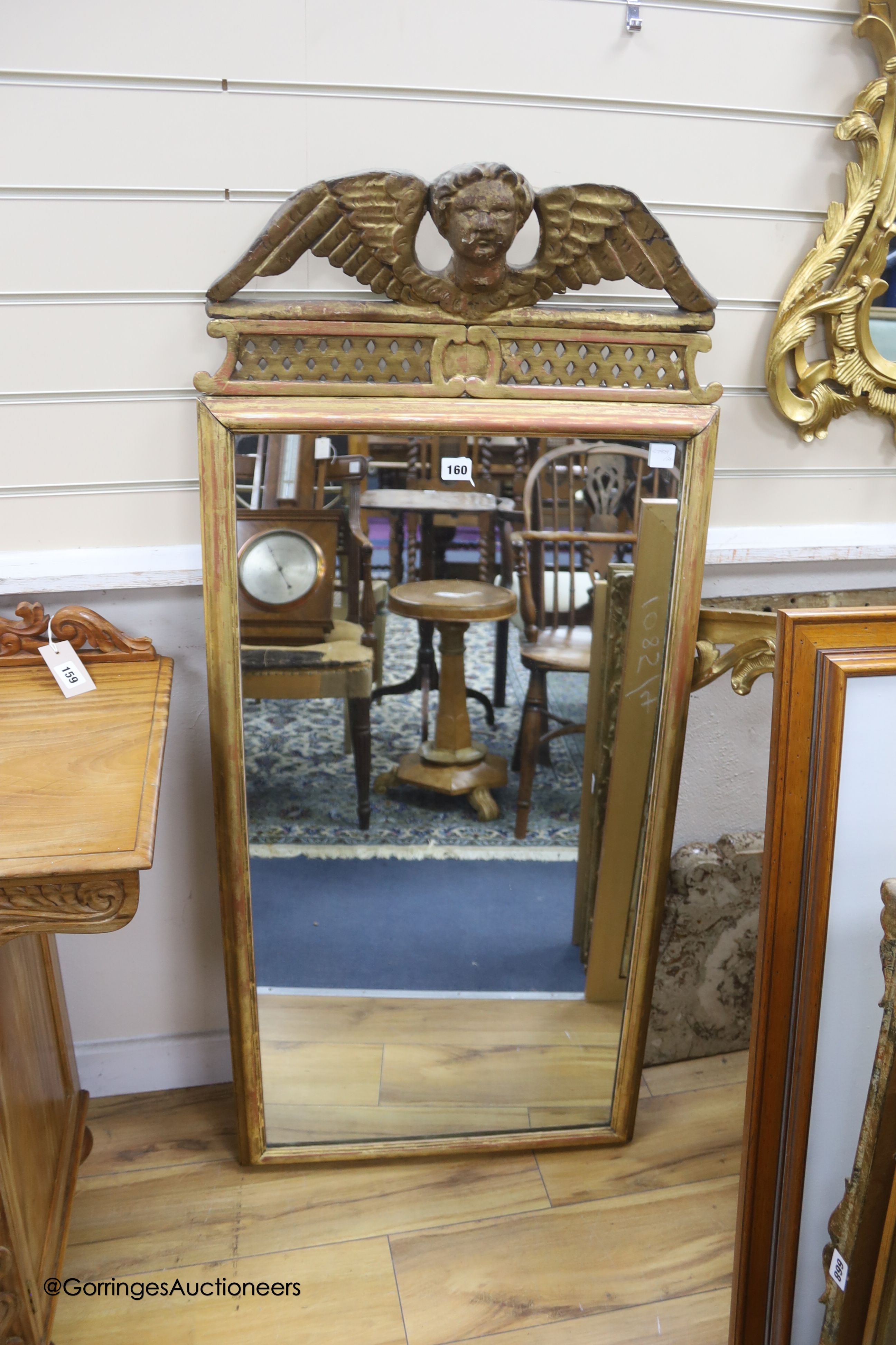 An 18th century giltwood mirror, with carved cherub cresting